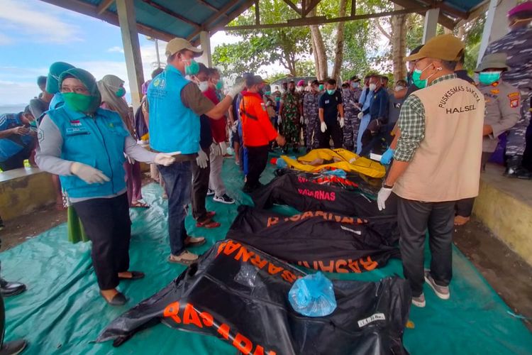 This handout picture taken and released on July 21, 2022 by Indonesia's National Search And Rescue Agency (BASARNAS) shows a rescue team next to victim's bodies after a ferry sank in bad weather in waters off Indonesia's Ternate island. The KM Cahaya Arafah capsized in waters off Indonesia's Ternate island on July 18, prompting a search and rescue operation for 13 missing people. (Photo by Handout / BASARNAS / AFP) 