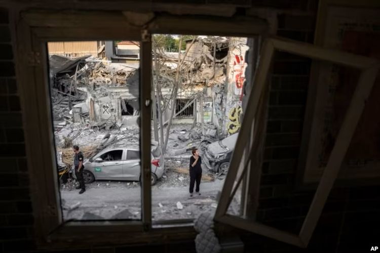 Warga Israel memeriksa puing-puing sebuah bangunan sehari setelah terkena roket yang ditembakkan dari Jalur Gaza, di Tel Aviv, Israel, 8 Oktober 2023.