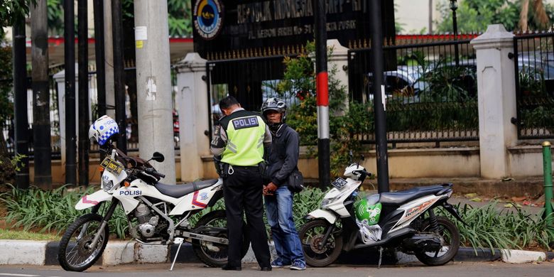 Polisi merazia pengendara sepeda motor yang melintasi trotoar di Jalan Kebon Sirih, Jakarta Pusat, Senin (17/7/2017). Pengendara sering memanfaatkan trotoar untuk memotong jalan agar bisa lebih cepat ketimbang melewati jalan raya.