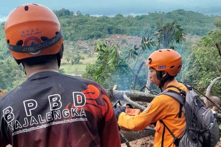 Petugas tengah menangani material longsor yang menutup jalur nasional Majalengka-Kuningan, Rabu (6/3/2024).