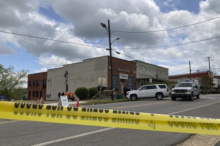 Penyelidik bekerja di lokasi penembakan di pusat kota Dadeville, Alabama, pada Minggu (16/4/2023). Beberapa orang tewas dalam penembakan di pesta ulang tahun pada Sabtu (15/4/2023) malam.