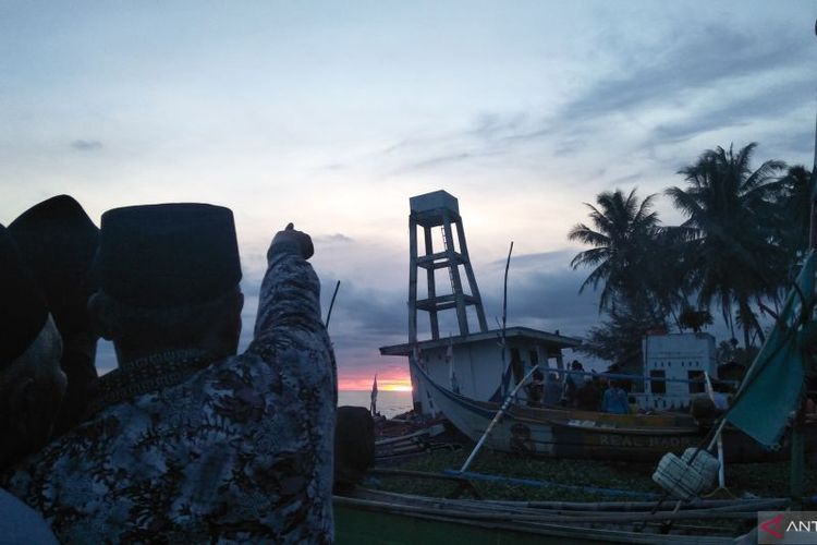 Seorang jamaah tarikat Syattariyah di Kabupaten Padang Pariaman, Sumbar menunjuk bulan untuk memberitahukan jamaah lainnya pada tradisi 'maniliak bulan' di Kecamatan Ulakan Tapakis. 