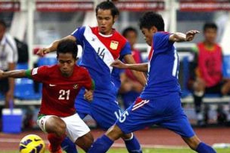 Pemain Timnas Indonesia Andik Vermansah dihadang dua pemain Laos Sopha Saysana (tengah) dan Viengsavanh Sayyaboun saat laga AFF Suzuki Cup 2012 grup B di Stadion Bukit Jalil, Kuala Lumpur, Malaysia, Minggu (25/11/2012).