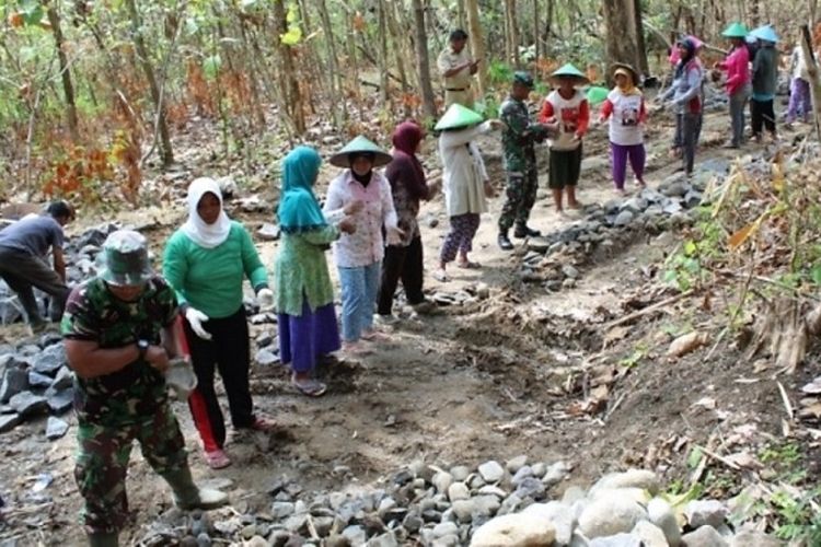 Warga bersama anggota TNI di Desa Cikuya, Banjarharjo, Brebes, Jawa Tengah, berkerja bersama saat program TMMD Reguler ke 100.