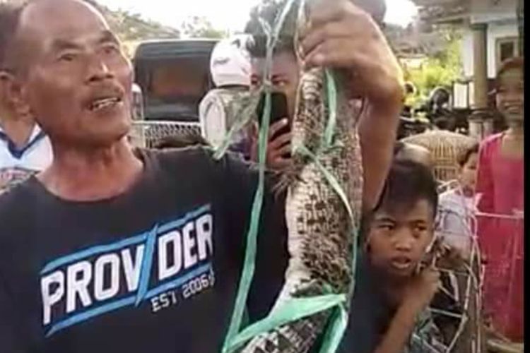 Abah Sabren tunjukan anak buaya yang berhasil ditangkap saat memancing di pesisir Waduk Jatigede di wilayah Wado, Sumedang, Rabu (24/6/2020). Screenshoot Facebook/KOMPAS.com