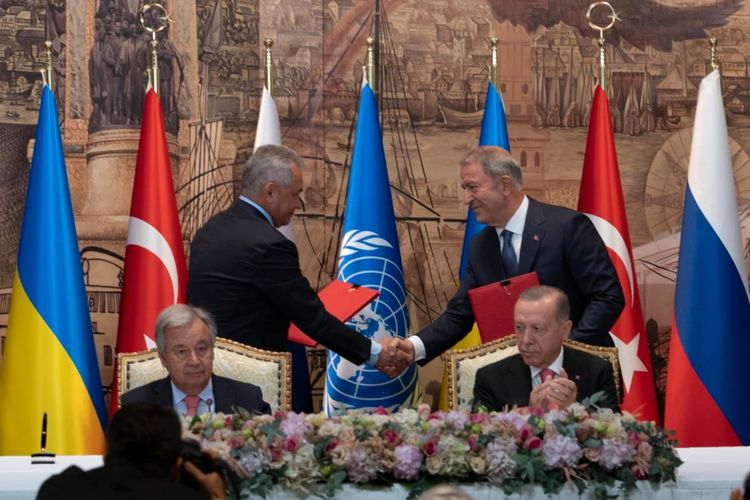 Presiden Turkiye Recep Tayyip Erdogan dan Sekjen PBB Antonio Guterres duduk saat dua perwakilan delegasi Ukraina dan Rusia berjabat tangan selama upacara penandatanganan perjanjian ekspor gandum Ukraina di Istana Dolmabahce, Istanbul, Turki, Jumat (22/7/2022).