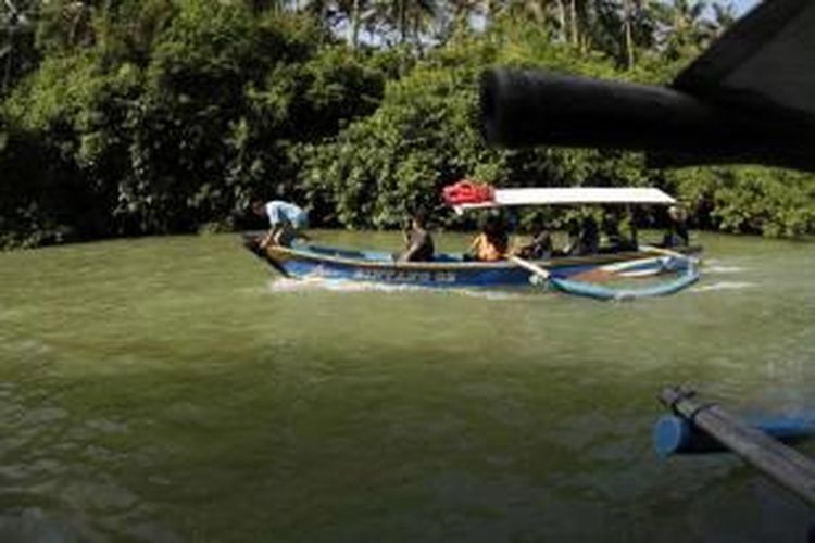 Wisatawan menggunakan perahu mengunjungi obyek wisata Green Canyon, Cijulang, Pangandaran, Jawa Barat, Sabtu (4/5/2013). Obyek wisata ini menawarkan keindahan dinding bebatuan yang ditutupi lumut dan wisatawan dapan menikmatinya dengan menyusuri sungai menggunakan perahu.