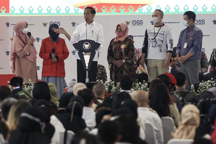 Presiden Joko Widodo berbincang dengan pelaku UMKM saat pembagian nomor induk berusaha (NIB) di Cijantung, Jakarta, Rabu (13/7/2022). Jokowi menargetkan, ke depannya pemerintah dapat mengeluarkan 100.000 izin usaha per hari, dari angka 7.000-8.000 izin usaha per hari saat ini.