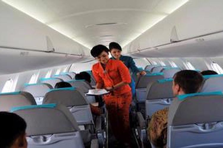 Pramugari Garuda Indonesia melayani penumpang.