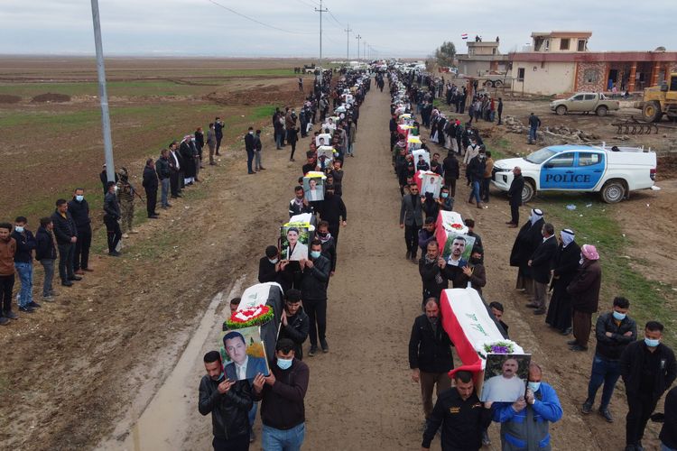 Sebuah gambar dari udara menunjukkan pelayat membawa peti mati dari 104 korban Yazidi dari serangan ISIS di desa Kojo, Irak utara distrik Sinjar, pada 6 Februari 2021. [ZAID AL-OBEIDI/AFP]