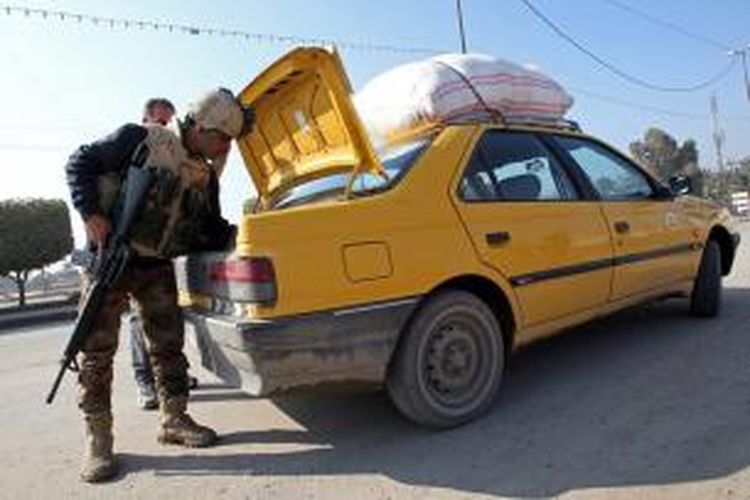 Seorang personel militer Irak memeriksa bagasi sebuah mobil di bagian timur kota Baghdad, sementara di kota Fallujah militer mempersiapkan serangan besar untuk merebut kota yang dikuasai kelompok militan ISIL itu.