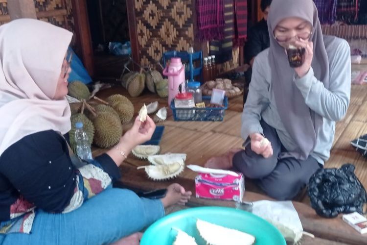 Pengunjung menikmati buah durian di kawasan permukiman Badui di Kabupaten Lebak, Banten dengan harga rata-rata Rp 30.000 per buah, Minggu (19/11/2023). 