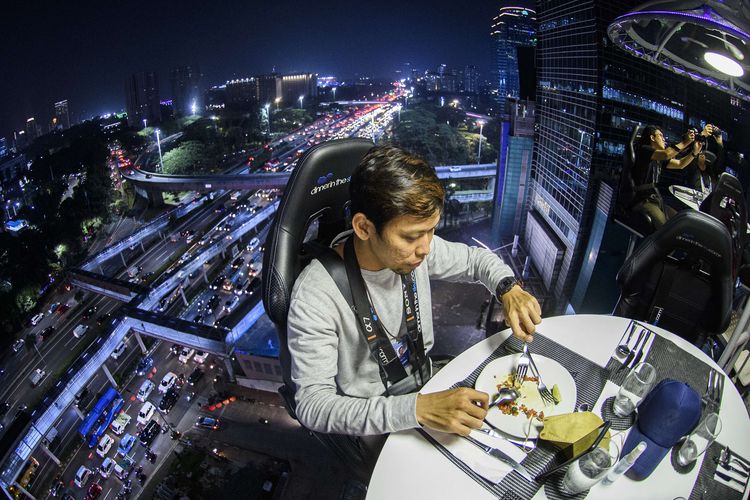 Pengunjung menyantap makanan dari ketinggian di Lounge in the Sky Indonesia di Jakarta, Selasa (29/3/2022). Destinasi wisata baru yang menawarkan sensasi menyantap hidangan dari ketinggian 50 meter dengan panorama Ibu Kota tersebut dapat dinikmati mulai dari harga Rp1,6 juta hingga Rp3,7 juta per orang.