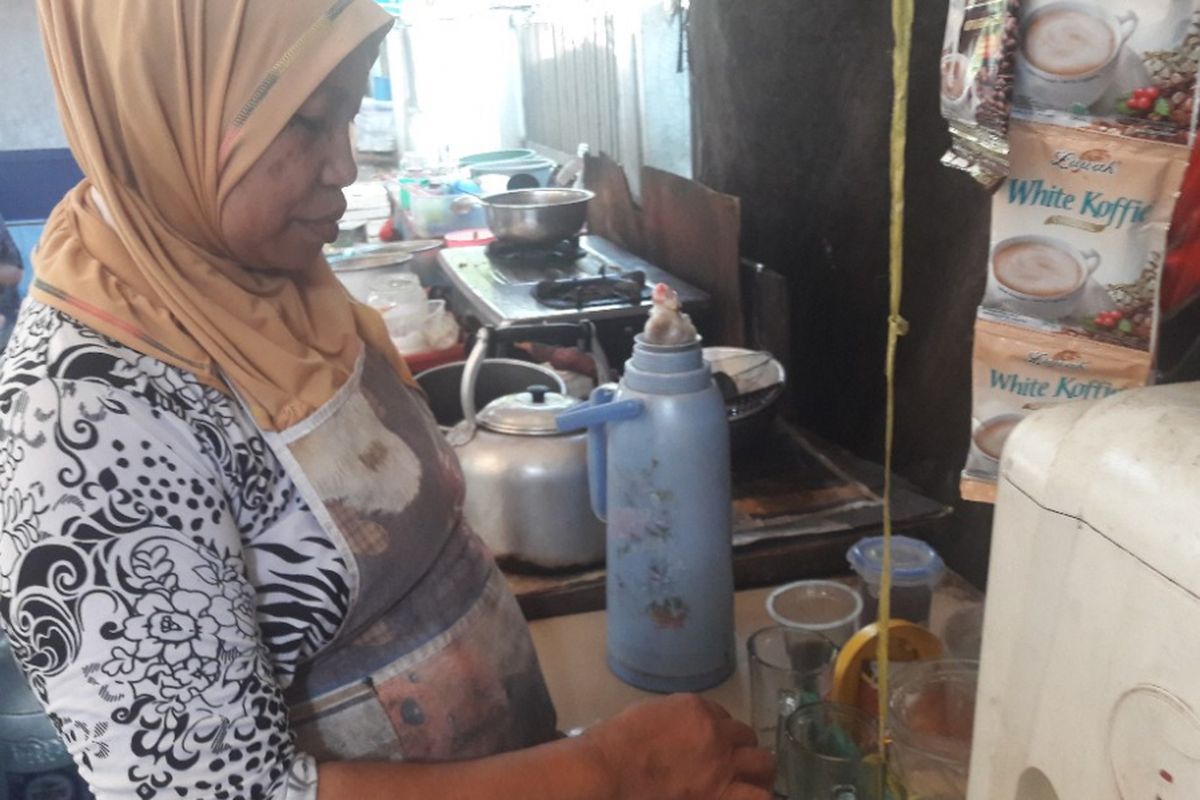 Mutia alias Ema tengah menyiapkan minuman di warungnya di Jalan Melur, dekat Mapolres Metro Jakarta Utara, Jumat (20/4/2018).