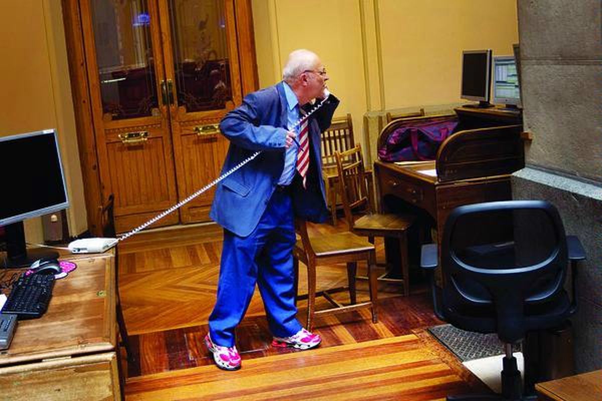 Seorang pialang  sibuk berbicara sembari melihat layar monitor yang menampilkan harga-harga saham Bursa Saham Madrid, Spanyol, Selasa (9/8). Dalam dua hari, atau pada hari Senin dan Selasa, para pialang disibukkan atau bahkan  panik dengan gejolak tinggi harga-harga saham.