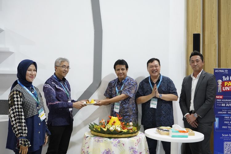Bambang Widjanarko selaku Chief Operating Officer Astra UD Trucks menyerahkan simbolis tumpeng kepada Vica Krisdianatha, Direktur Utama atau CEO PT Pro Energi