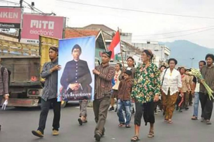 Sebuah poster bergambar seorang pria mengenakan beskap dan tutup kepala berwarna hitam dibopong dua orang pria berpakain sorjan menyusuri Jalan Jenderal Sudirman, Ambarawa, Kabupaten Semarang, Sabtu (20/5/2017) sore. 