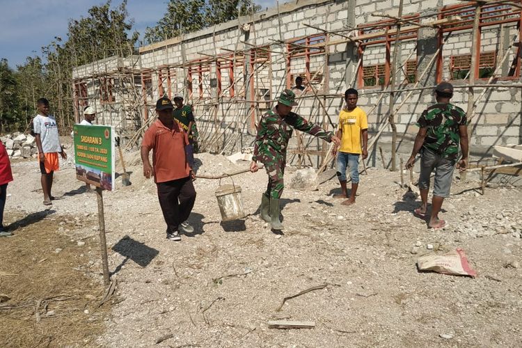 Paulus Ataupah Kepala Sekolah SMP Negeri 6 Amarasi Timur, Satap Kuanneke, Desa Oebesi, Kecamatan Amarasi Timur, Kabupaten Kupang, Nusa Tenggara Timur (NTT), saat mengangkat pasir di dalam ember bersama seorang anggota TNI untuk membantu pembangunan sekolah tersebut