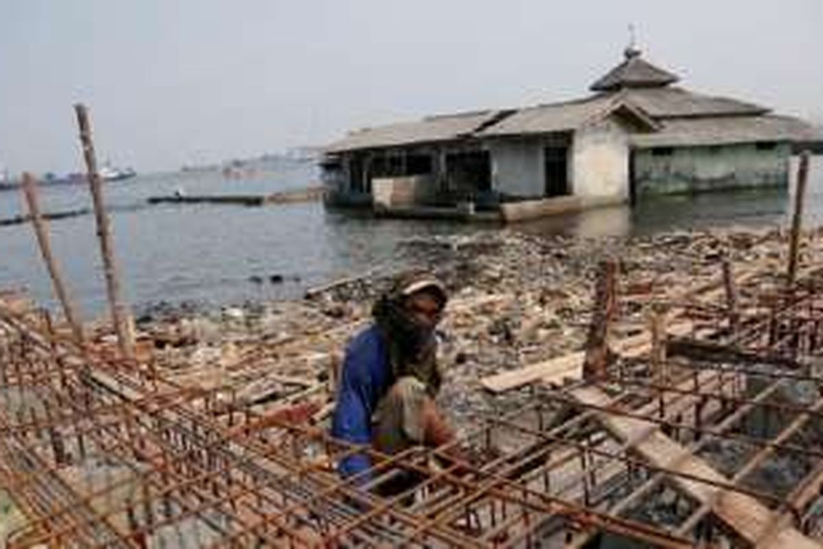 Pekerja membangun tanggul laut di pesisir Muara Baru, Penjaringan, Jakarta Utara, Senin (30/11). Tanggul laut yang dibangun oleh Pemerintah Provinsi DKI Jakarta itu untuk meminimalisir banjir rob yang terus meluas akibat penurunan muka tanah serta peningkatan muka air laut. 