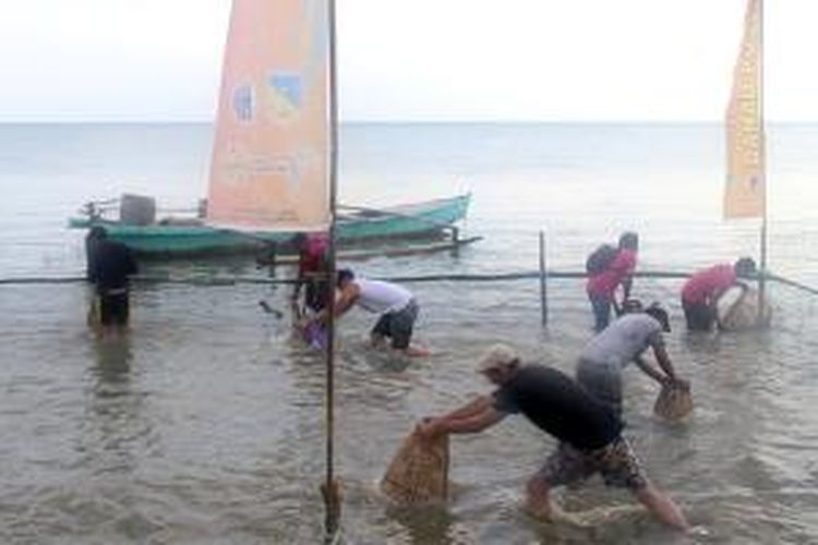Dua wisatawan mancanegara berpartisipasi dalam lomba tangkap ikan menggunakan keranjang anyaman bambu (mosango) di Tepi Danau Poso, Tentena, Kecamatan Pamona Puselemba, Kabupaten Poso, Sulawesi Tengah, Sabtu (30/8/2014). Acara itu merupakan bagian dari rangkaian Festival Danau Poso XVII.