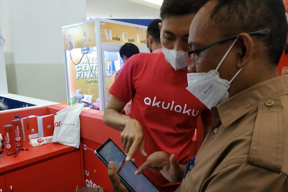 Salah satu pegawai Akulaku sedang menjelaskan produk Akulaku dalam pameran Multifinance Day 2022 di Bandung.