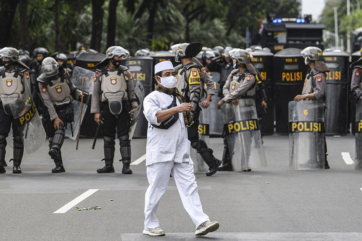 Seorang pengunjuk rasa aksi demonstrasi 1812 berjalan saat membubarkan diri, di kawasan Medan Merdeka Selatan, Jakarta, Jumat (18/12/2020). Kepolisian membubarkan paksa massa aksi demonstrasi dikarenakan angka penyebaran Covid-19 masih tinggi di wilayah Jakarta.