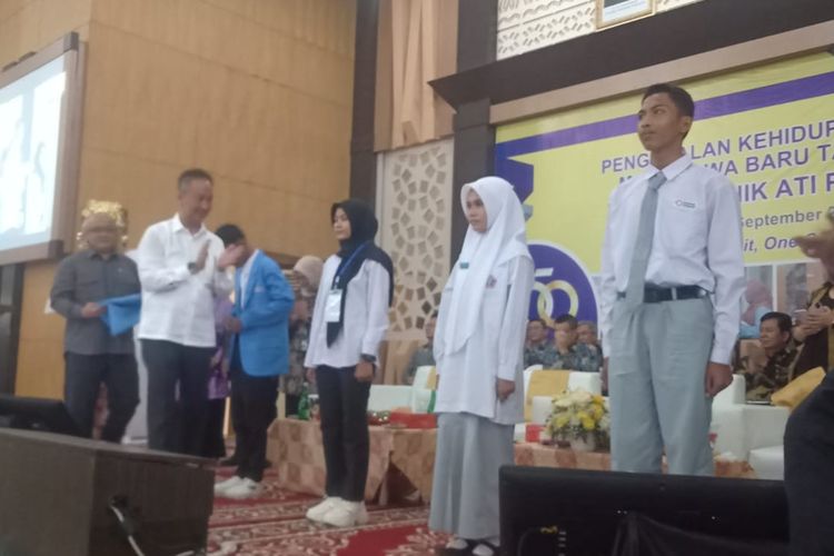 Menteri Perindustrian Agus Gumiwang memasang jaket almamater ke mahasiswa baru Politeknik ATI Padang, Senin (4/9/2023).