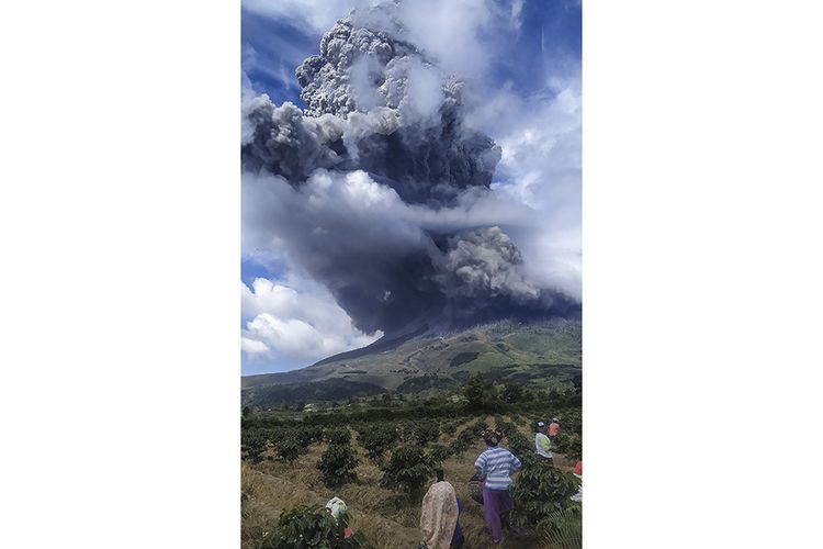 Warga mengamati Gunung Sinabung menyemburkan material vulkanik saat erupsi di Karo, Sumatera Utara, Senin (10/8/2020). Gunung Sinabung erupsi dengan tinggi kolom 5.000 meter di atas puncak atau sekitar 7.460 meter di atas permukaan laut.