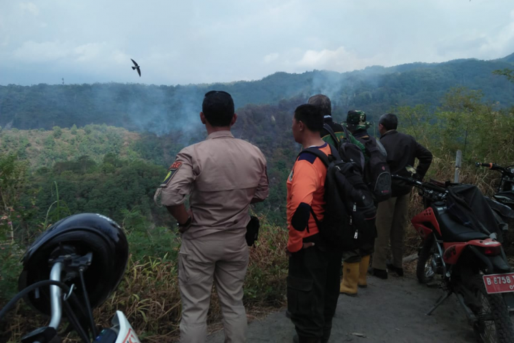Petugas memantau kebakaran hutan di kawasan hutan lindung Kepung, Kediri, Jawa Timur, Senin (10/9/2018).