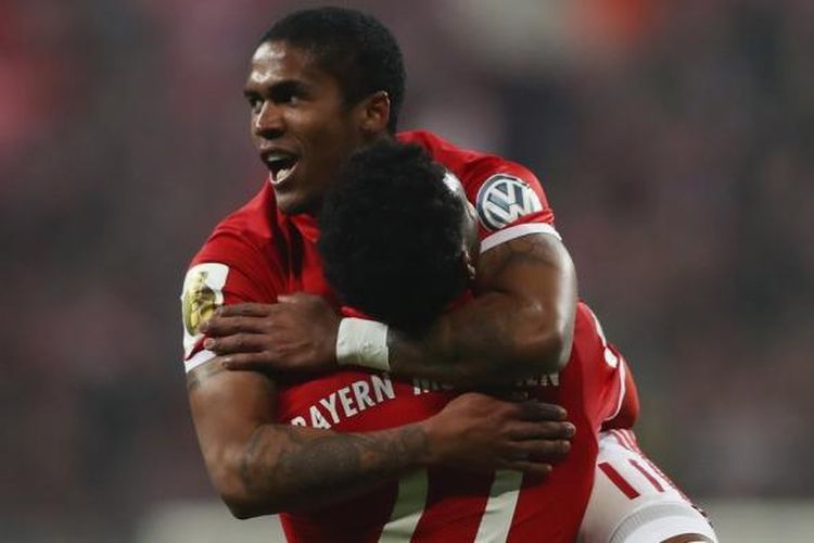 Douglas Costa dan David Alaba merayakan mencetak gol penentu kemenangan Bayern Muenchen atas Wolfsburg pada partai babak 16 besar DFB Pokal di Allianz Arena, Selasa (7/2/2017).