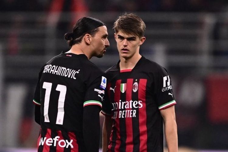 Penyerang AC Milan, Zlatan Ibrahimovic (kiri), berbicara dengan gelandang Charles De Ketelaere dalam laga melawan Salernitana. Laga AC Milan vs Salernitana pada pekan ke-26 Liga Italia Serie A 2022-2023 tersebut digelar di Stadion San Siro, Minggu (13/3/2023) malam waktu setempat. (Foto oleh Marco BERTORELLO / AFP)