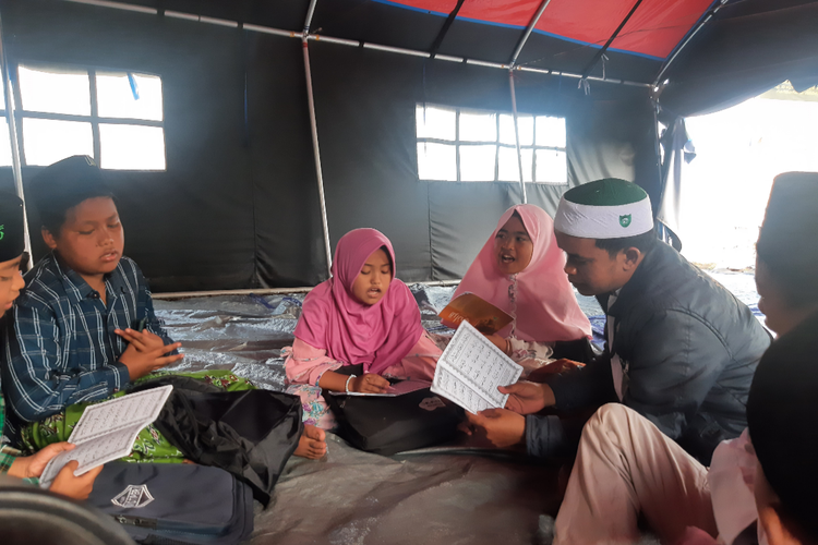 Kegiatan mengaji oleh anak-anak penyintas Semeru di tenda pengungsian lapangan Desa Penanggal, Kecamatan Candipuro, Kabupaten Lumajang, Kamis (7/4/2022)