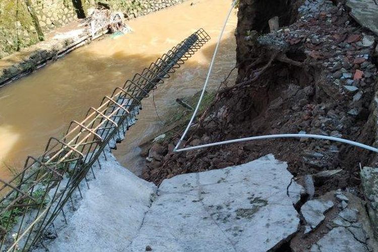 Jalan perkampungan di Kampung Neglasari, Desa Purwasari, Kecamatan Cicurug, Kabupaten Sukabumi, Jawa Barat ambles tergerus longsor. 
