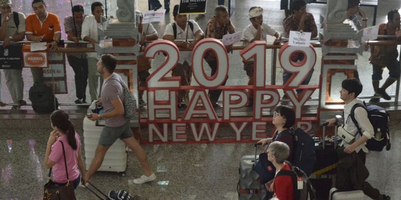 Sejumlah wisatawan membawa barang milik mereka setibanya di Bandara Internasional I Gusti Ngurah Rai, Bali, Kamis (27/12/2018). Bandara I Gusti Ngurah Rai mulai dipadati penumpang dari berbagai daerah yang akan berlibur dan merayakan pergantian tahun baru 2019 di Pulau Bali. Pada Rabu (26/12) tercatat sebanyak 17.168 penumpang penerbangan domestik dan 19.468 orang penumpang penerbangan internasional tiba di bandara tersebut.  