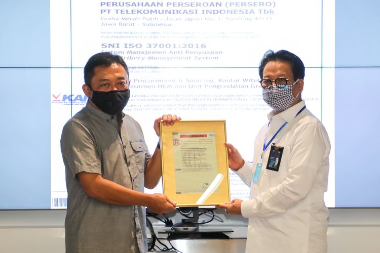 Direktur Utama Telkom Ririek Adriansyah (kiri) menerima sertifikat ISO 37001:2016 setelah Telkom menjalani sertifikasi penerapan Sistem Manajemen Anti Penyuapan sesuai dengan standar internasional, yang diserahkan oleh Direktur Utama Sucofindo Bachder Djohan Buddin (kanan) di Jakarta, Kamis (13/8/2020).