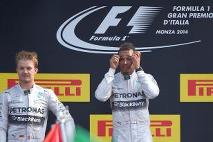 Pebalap Mercedes asal Inggris, Lewis Hamilton (kanan), berdiri di podium tertinggi Sirkuit Monza setelah memenangi GP Italia, Minggu (7/9/2014). Sementara rekan satu timnya, Nico Rosberg (Jerman) berdiri di posisi kedua.