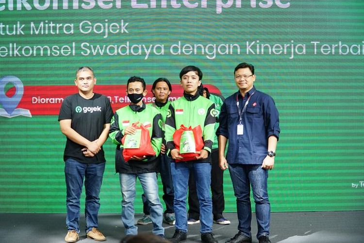 Penyerahan paket sembako kepada pengemudi Gojek oleh Telkomsel secara simbolis 

