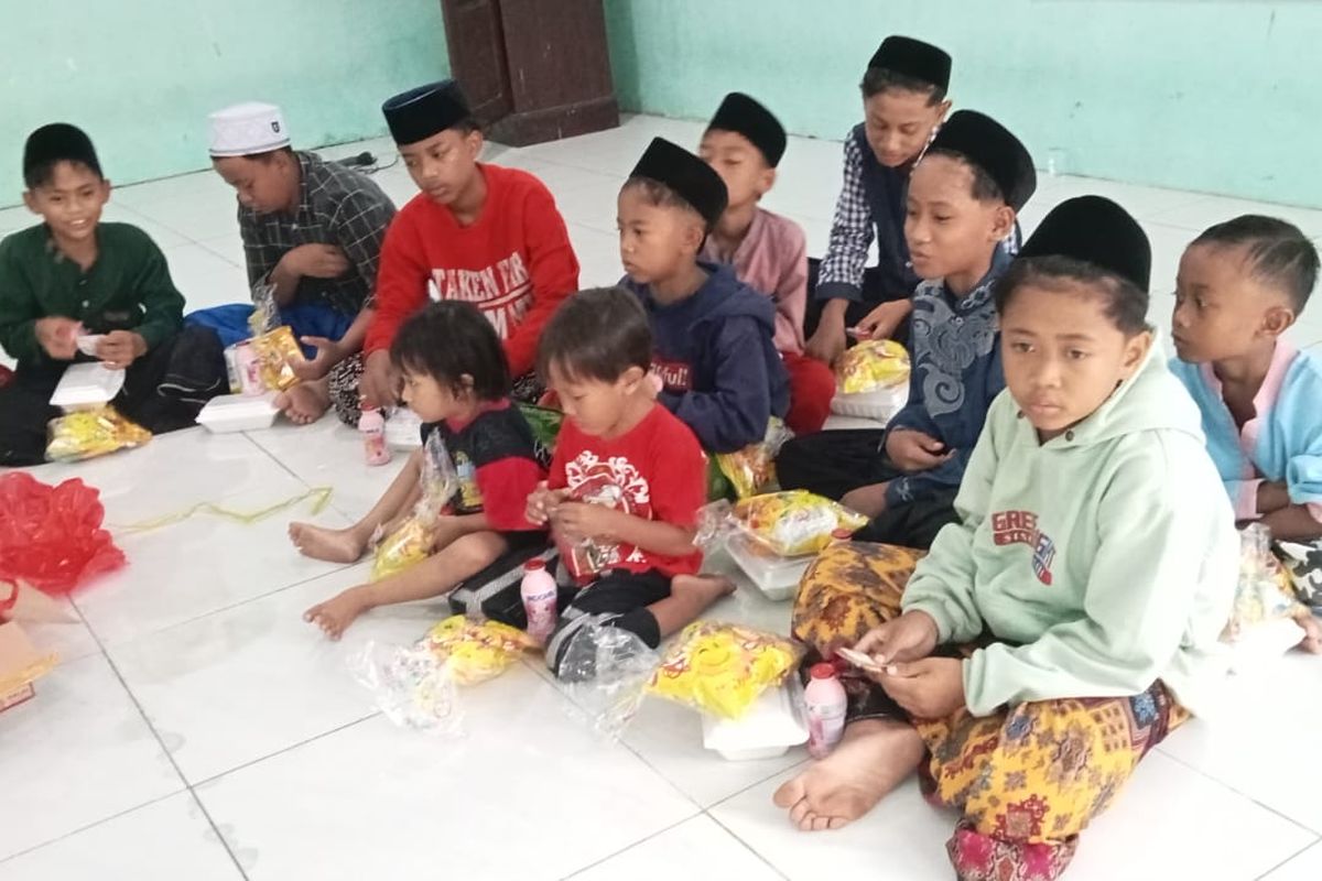 Anak-anak panti asuhan di Yayasan Assa'diyah di Desa Wonojati, Kecamatan Gondangwetan, sedang makan bersama. 