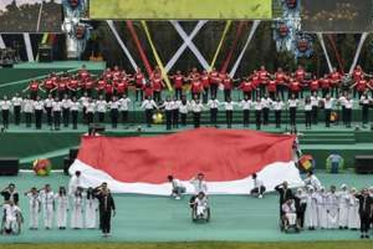 Penari membentangkan bendera merah putih raksasa saat penutupan Peparnas XV di Stadion Siliwangi, Bandung, Jawa Barat, Senin (24/10/2016). Peparnas XV 2016 resmi ditutup dan Jawa Barat menjadi juara umum dengan 178 medali emas, 104 perak dan 74 perunggu. 