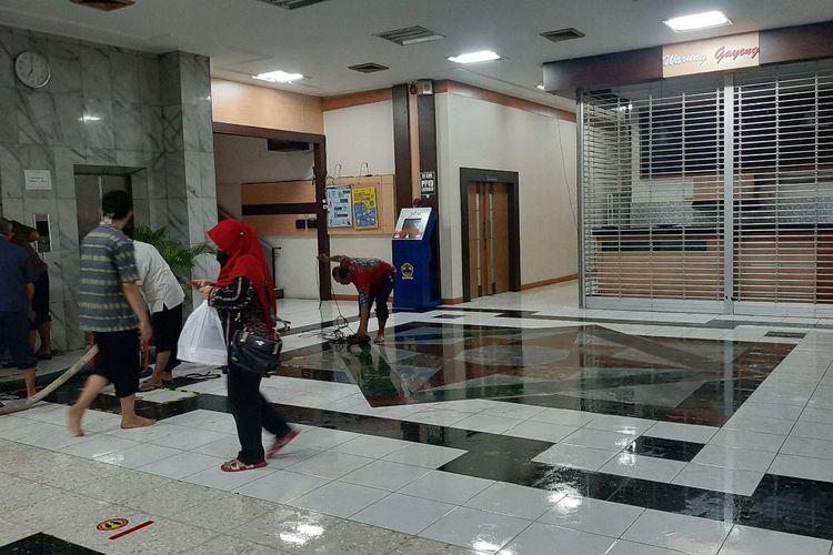 Petugas membersihkan lantai setelah genangan air memasuki Gedung B, Kantor Gubernuran Jateng, Selasa (23/2/2021).