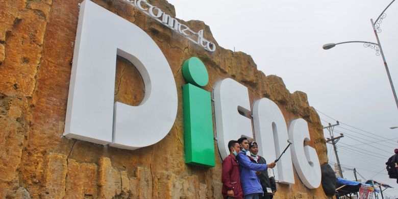 Pengunjung berswafoto di tugu Dieng, Jawa Tengah, Kamis (3/8/2017). Satu hari menjelang perhelatan Dieng Culture Festival 2017, pengunjung mulai memadati kompleks wisata Dieng.