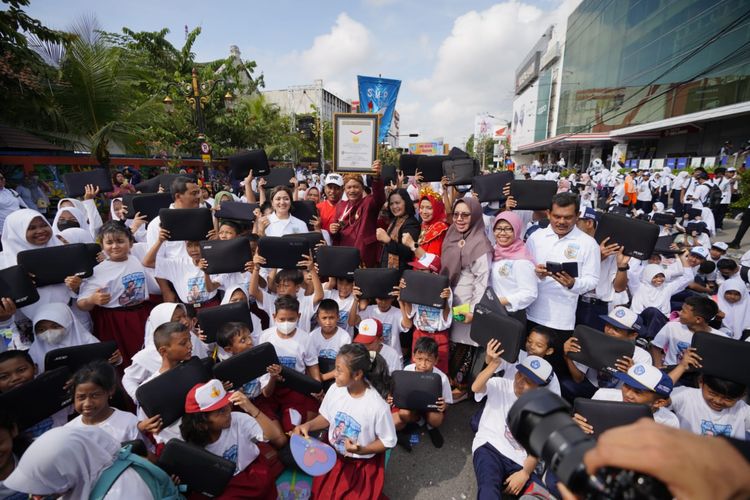 Siswa SD dan SMP mengangkat laptop yang diberikan gratis Pemkot Madiun pada peringatan Hari Pendidikan Nasional 2023, Selasa (2/5/2023). Pembagian 9.400 laptop gratis juga memecakan rekor MURI. 
