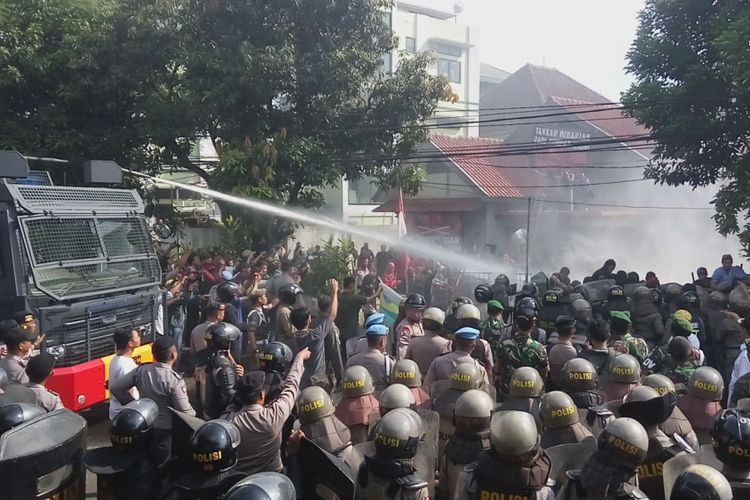 Mobil water canon menyemprotkan air ke arah mahasiswa yang menolak eksekusi pengosongan Wisma Latimojong, di Jalan Semeru, Kota Bogor, Kamis (27/4/2017).