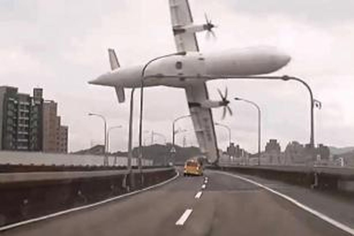 Foto dari rekaman video yang disediakan TVBS Taiwan pada 4 Februari 2015 menunjukkan pesawat TransAsia ATR 72-600 turboprop miring saat jatuh menabrak sungai Keelung, di New Taipei City, Taiwan, 4 Februari 2015. Sedikitnya 16 orang tewas dalam pesawat yang mengangkut 58 orang ini jatuh ke sungai.