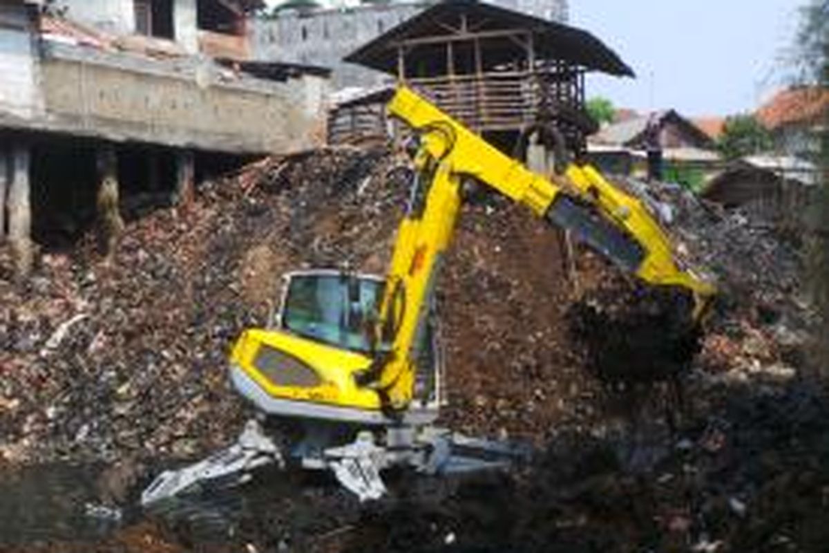 Pemandangan alat berat sedang mendaki gunungan sampah di Kali Cipinang. Rencananya, gunungan sampah itu akan dikeruk dan kemudian ditata kembali. Selasa (22/9/2015)