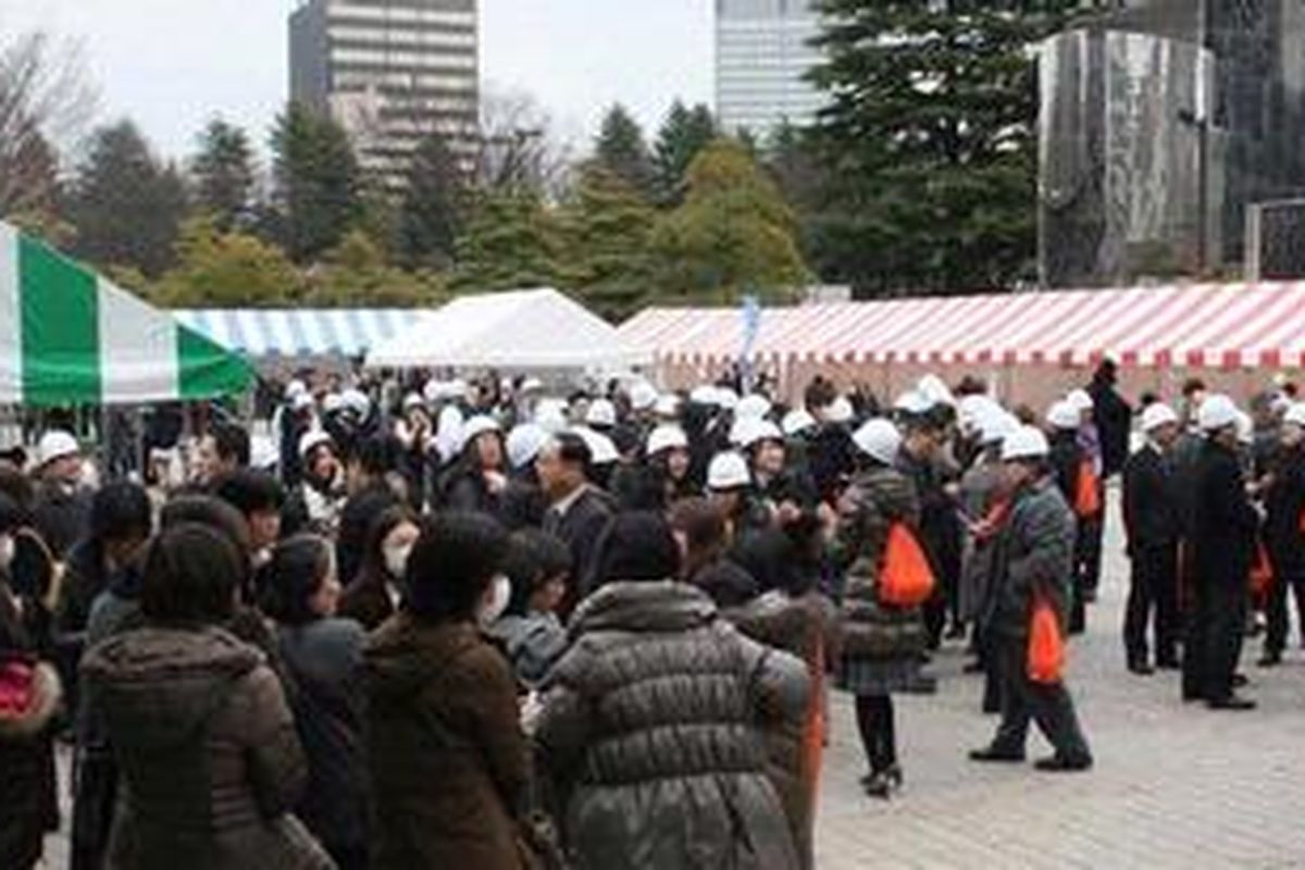 Warga Jepang di Kota Sendai, Fukushima berkumpul di taman setelah gempa berkekuatan 8,9 mengguncang Jepang, Jumat (11/3/2011). Mereka mengenakan pelindung kepala untuk mengamankan diri.