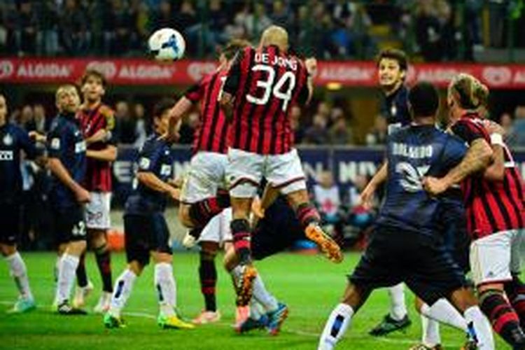 Gelandang AC Milan, Nigel De Jong, menyundul umpan Mario Balotelli masuk ke gawang Inter Milan, pada pertandingan Serie-A, di San Siro, Minggu (4/5/2014).
