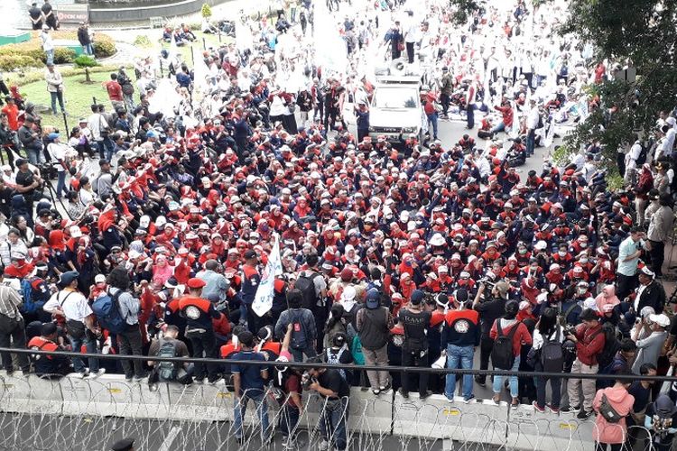 Massa peserta aksi Hari Buruh Internasional (May Day) 2019 dari KSPN menggelar orasi di hadapan barikade kawat berduri di Jalan Medan Merdeka Barat, Rabu (1/5/2019).