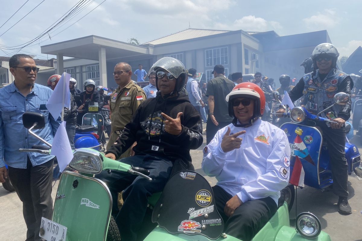 Bakal calon wali kota Sukabumi, Achmad Fahmi (kanan), menaiki Vespa saat hendak berangkat ke kantor KPU Kota Sukabumi. Selasa (27/8/2024) siang.