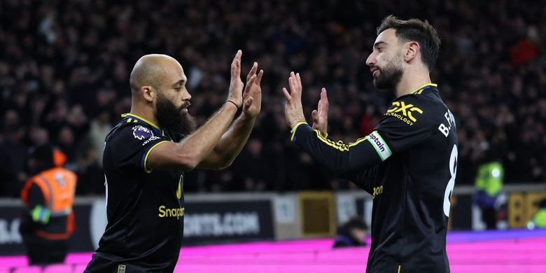 Bryan Mbeumo (kiri) merayakan gol dengan Bruno Fernandes dalam pertandingan sepak bola Liga Inggris antara Wolverhampton Wanderers vs Manchester United di stadion Molineux di Wolverhampton, Inggris tengah pada 8 Desember 2025. (Foto oleh Darren Staples / AFP)